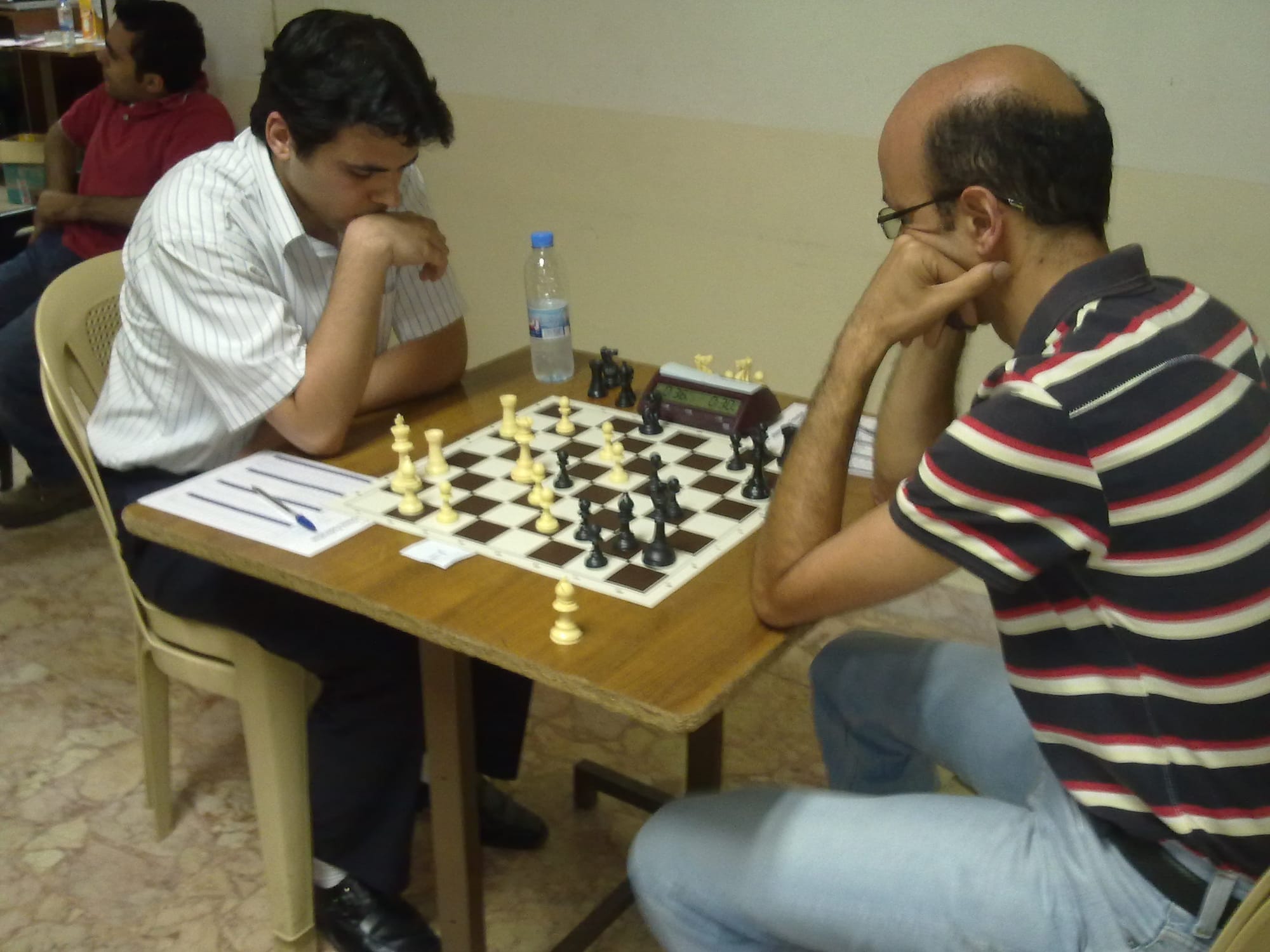 Two players concentrating with clock and scoresheets