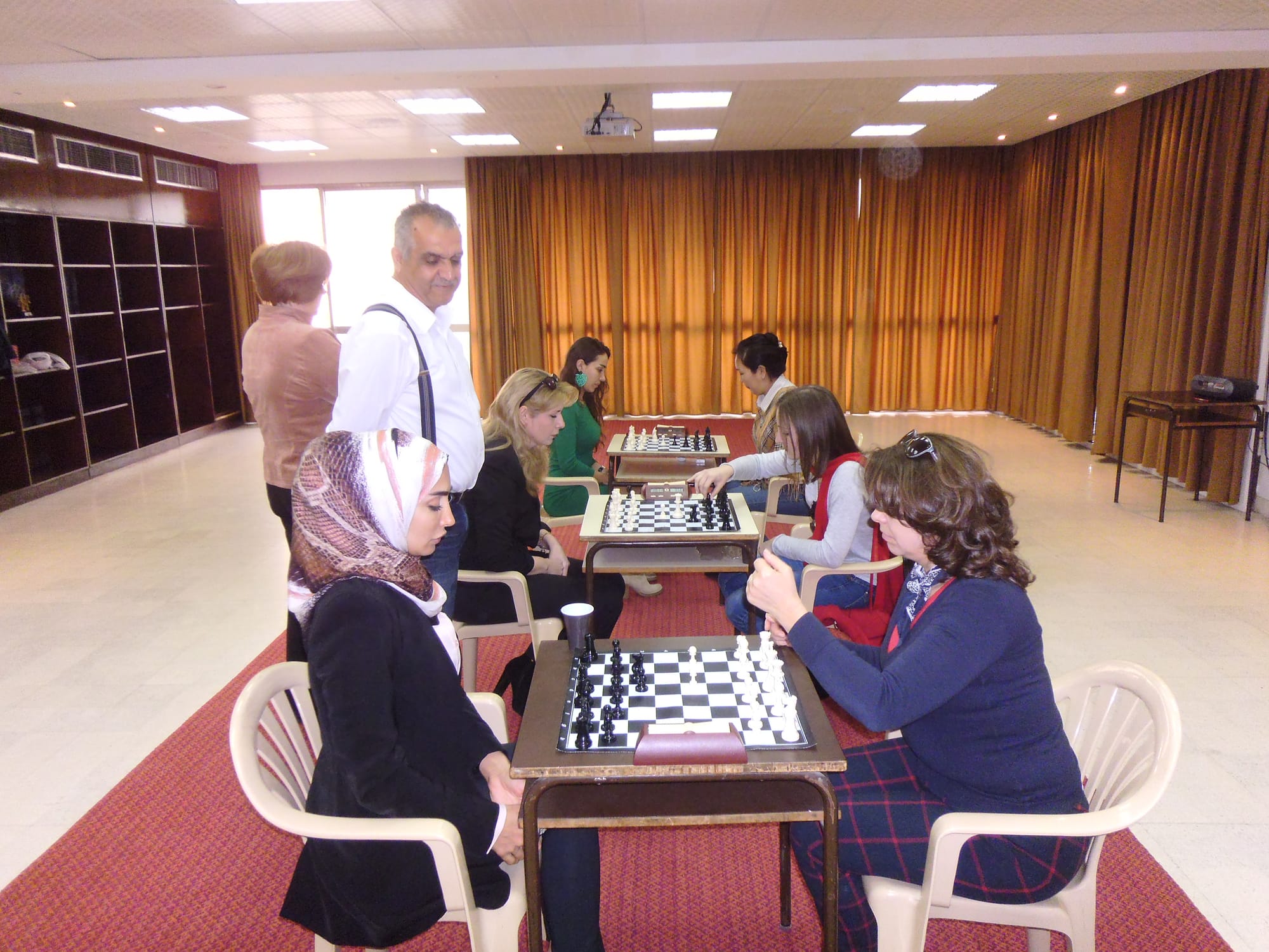 Players face off across the boards in a bright tournament hall