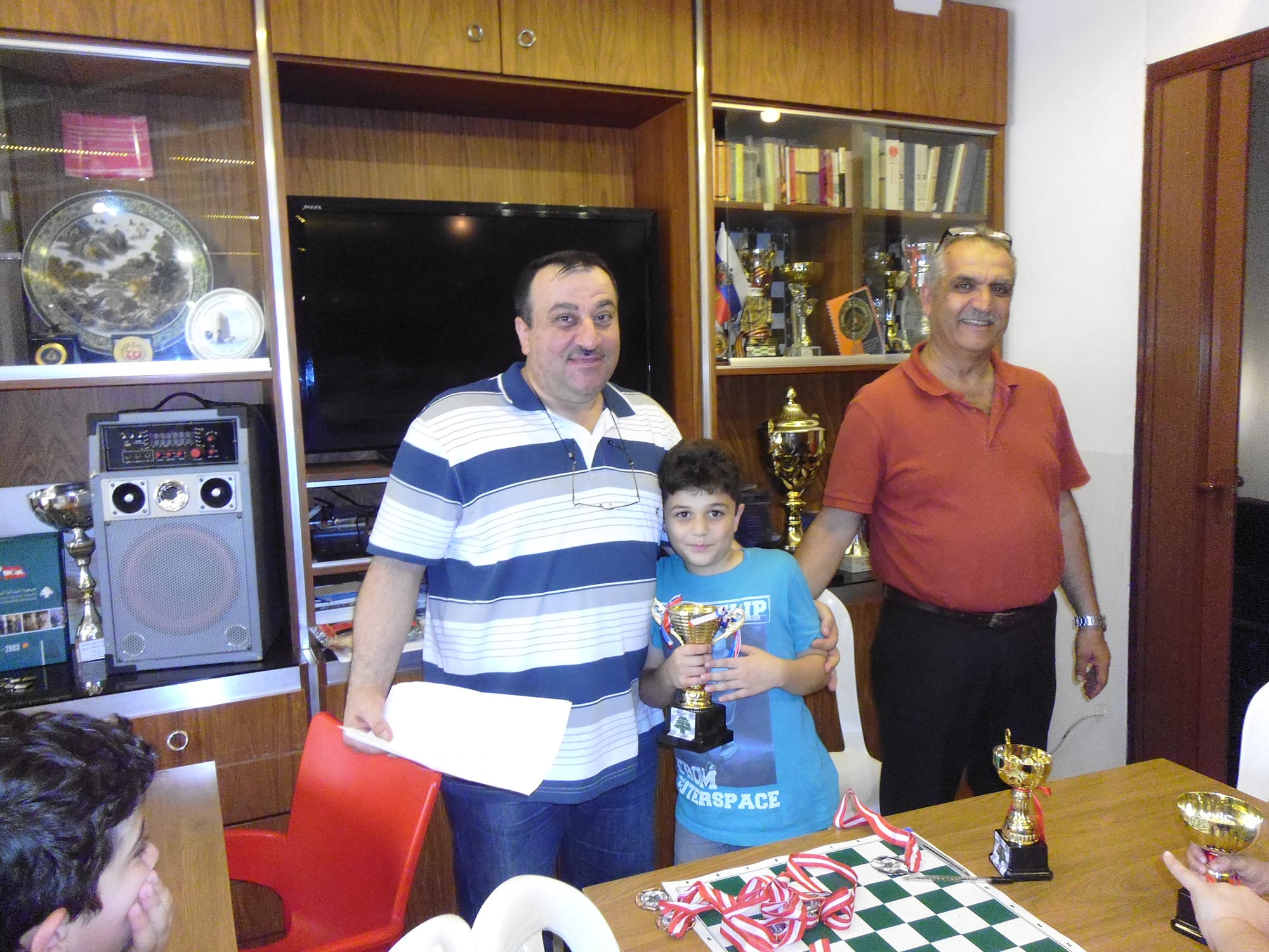Young champion receives his trophy from the club coaches