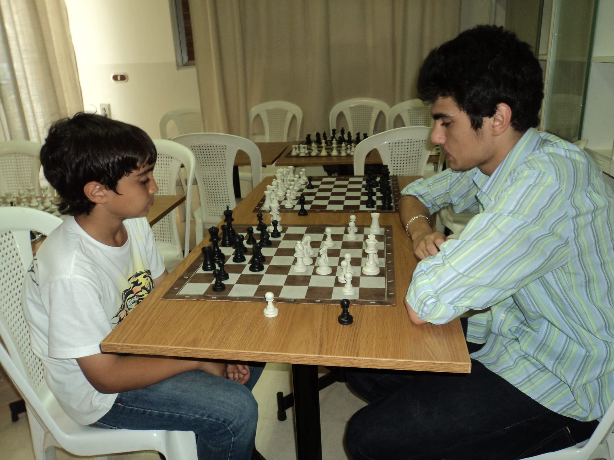 Junior member facing an older player across the board