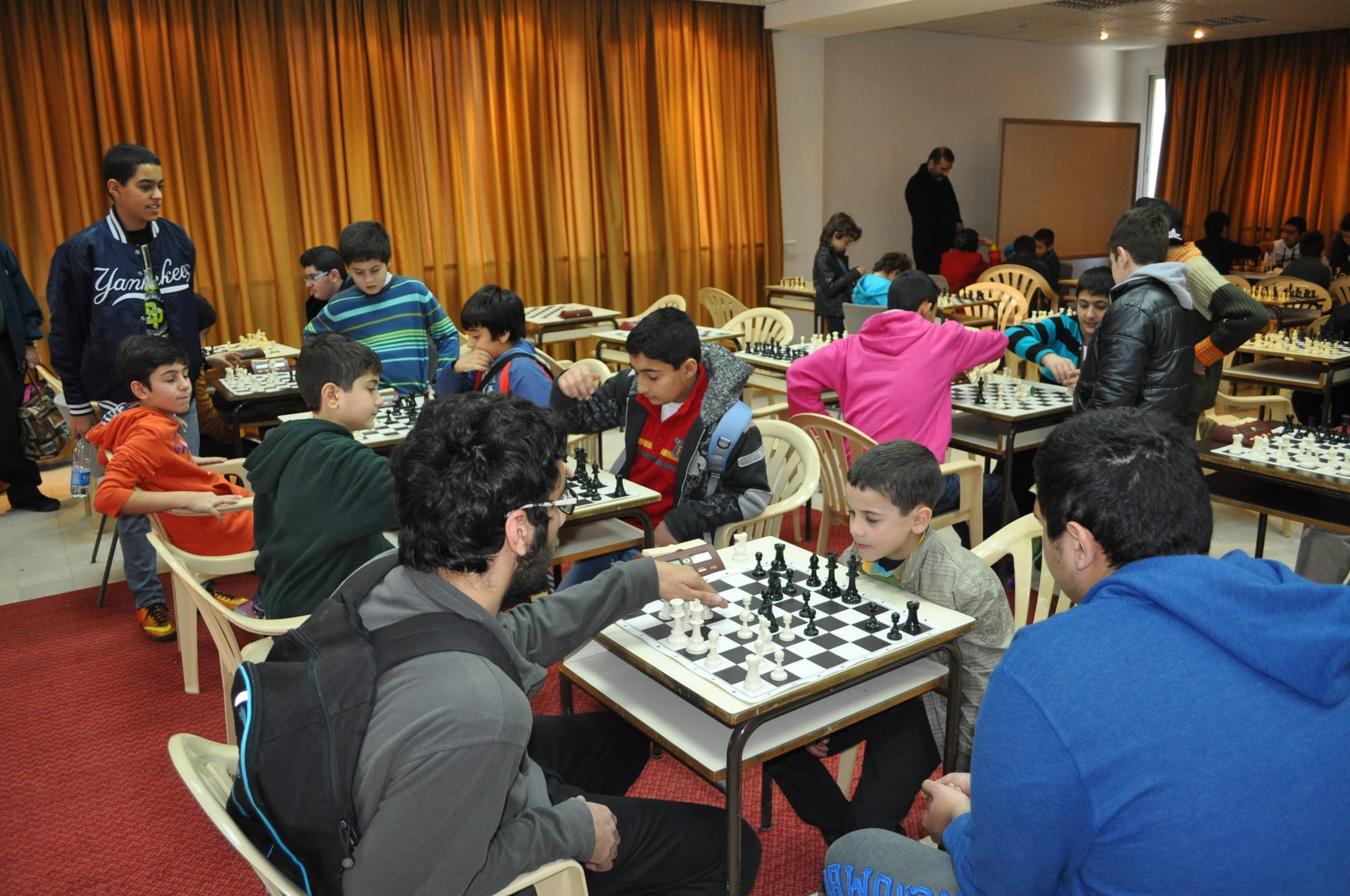 Young players absorbed in their games at a busy junior tournament